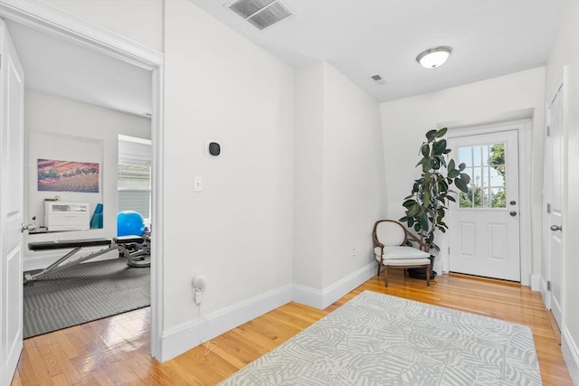 foyer featuring baseboards, visible vents, and light wood-style floors
