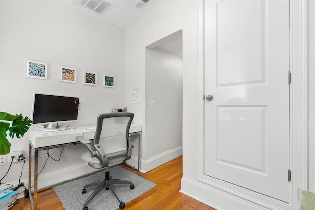 office featuring visible vents, baseboards, and light wood-type flooring
