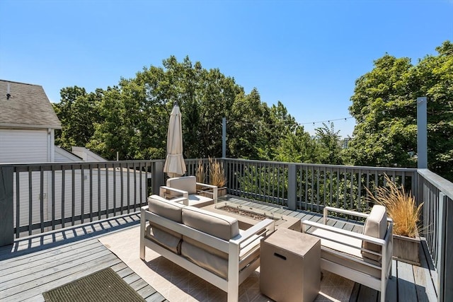 wooden deck featuring an outdoor living space with a fire pit