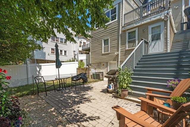 view of patio / terrace featuring fence, cooling unit, area for grilling, and a balcony
