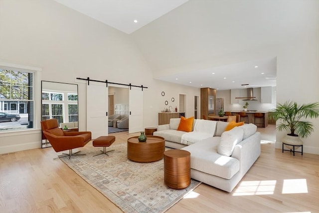 11 Cuba St, Andover, MA 01810 - living room featuring baseboards, a barn door, high vaulted ceiling, and light wood-style floors