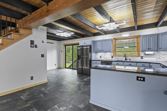 kitchen featuring stainless steel appliances, wooden ceiling, a sink, tasteful backsplash, and beam ceiling