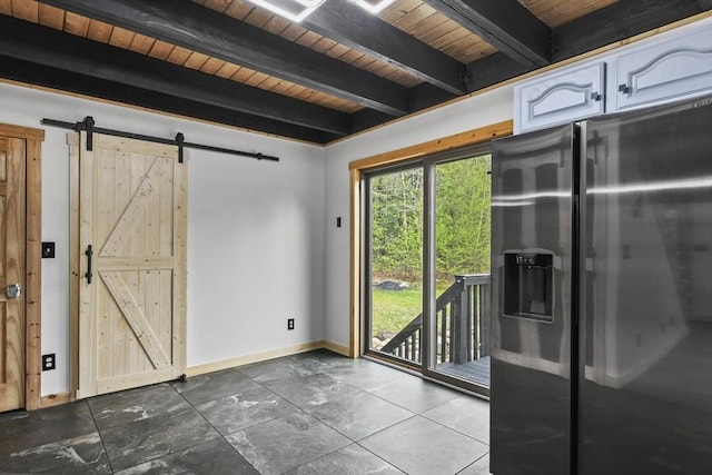 doorway to outside featuring wood ceiling, beamed ceiling, a barn door, and baseboards