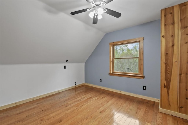 bonus room featuring lofted ceiling, light wood-style flooring, baseboards, and ceiling fan