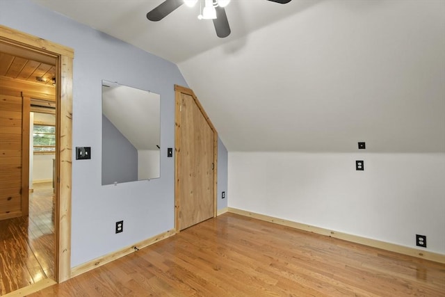 bonus room with a ceiling fan, wood finished floors, vaulted ceiling, and baseboards