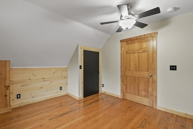bonus room featuring lofted ceiling, light wood-style flooring, ceiling fan, and baseboards