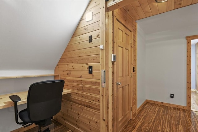 office area with wooden walls, lofted ceiling, dark wood finished floors, and baseboards