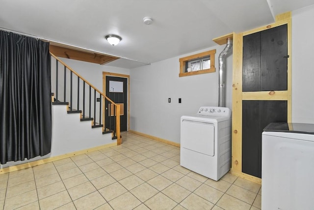 clothes washing area with washer / dryer and baseboards