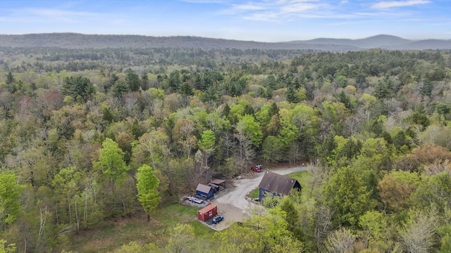 aerial view of property and surrounding area featuring a heavily wooded area
