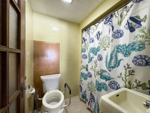 full bathroom featuring tile patterned floors, curtained shower, toilet, and a sink