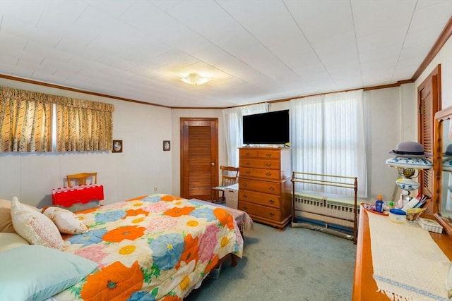 bedroom with ornamental molding and carpet flooring