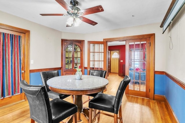 dining space with ceiling fan and light wood-type flooring