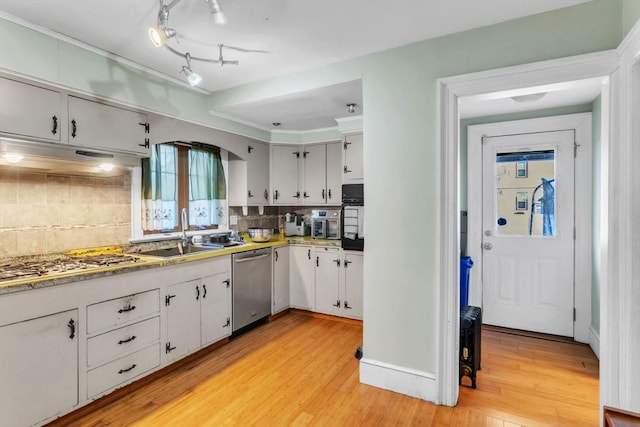 kitchen with white cabinetry, appliances with stainless steel finishes, backsplash, and sink