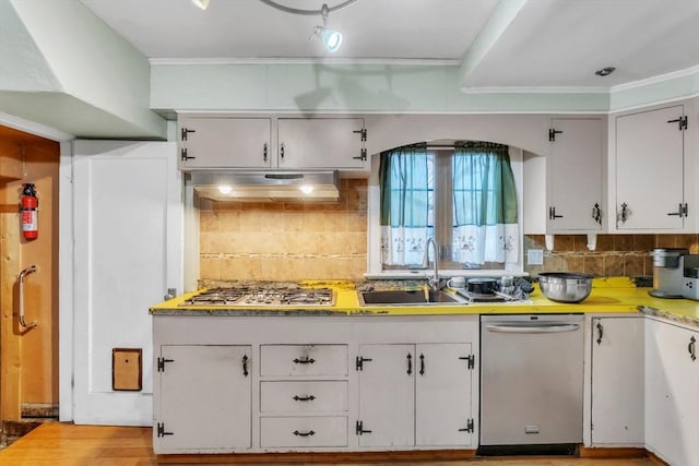 kitchen with white cabinets, backsplash, appliances with stainless steel finishes, and sink