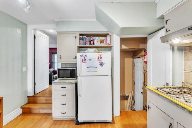 kitchen with light hardwood / wood-style floors, white cabinetry, and appliances with stainless steel finishes