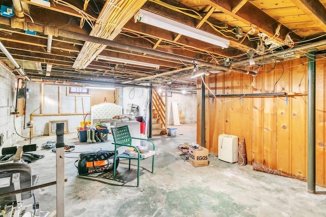 basement featuring wooden walls