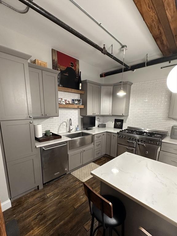 881 E 1st St Unit 303, Boston, MA 02127 - kitchen featuring gray cabinets, a sink, stainless steel appliances, decorative backsplash, and dark wood finished floors