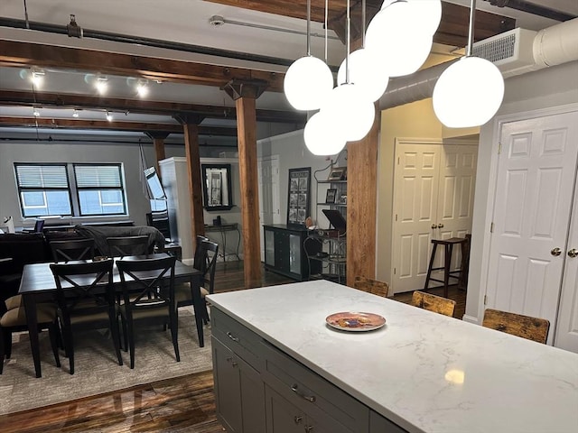 881 E 1st St Unit 303, Boston, MA 02127 - kitchen featuring gray cabinetry, dark wood-style flooring, beam ceiling, hanging light fixtures, and light stone counters