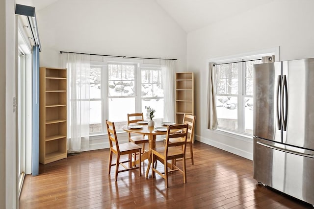 dining area featuring hardwood / wood-style flooring and high vaulted ceiling