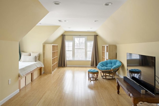 additional living space with light hardwood / wood-style floors and lofted ceiling