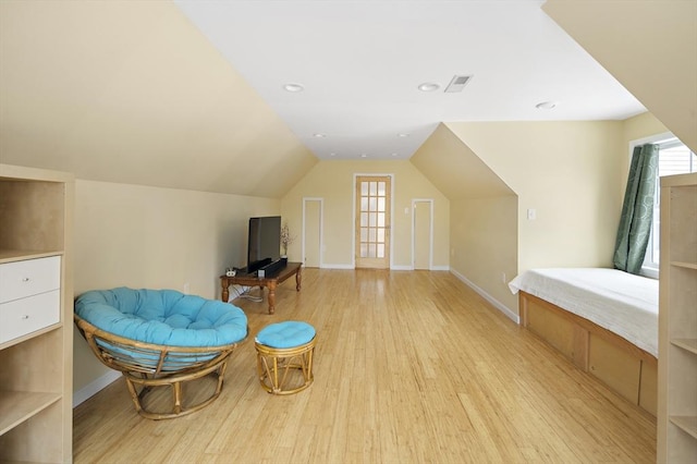 living area with light wood-type flooring and lofted ceiling