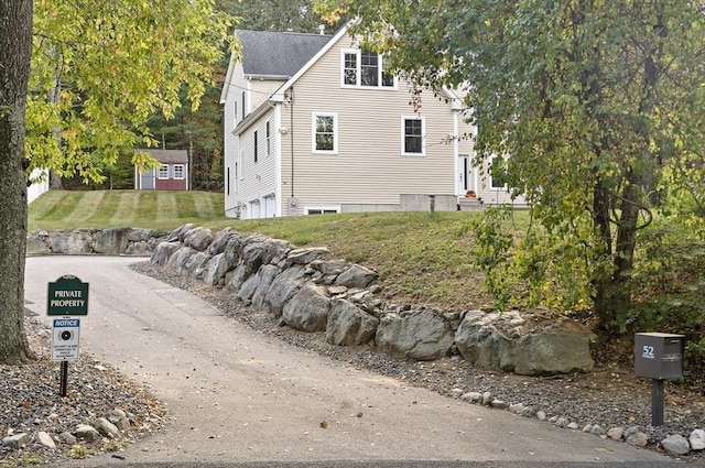 view of side of home featuring a storage shed