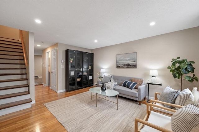 living room featuring stairs, recessed lighting, baseboards, and light wood finished floors