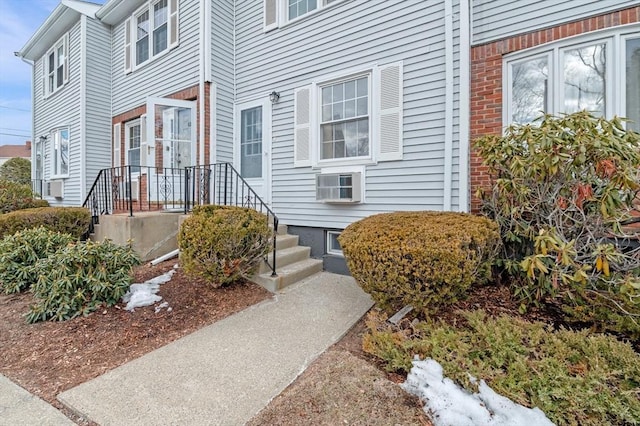 entrance to property with brick siding and cooling unit