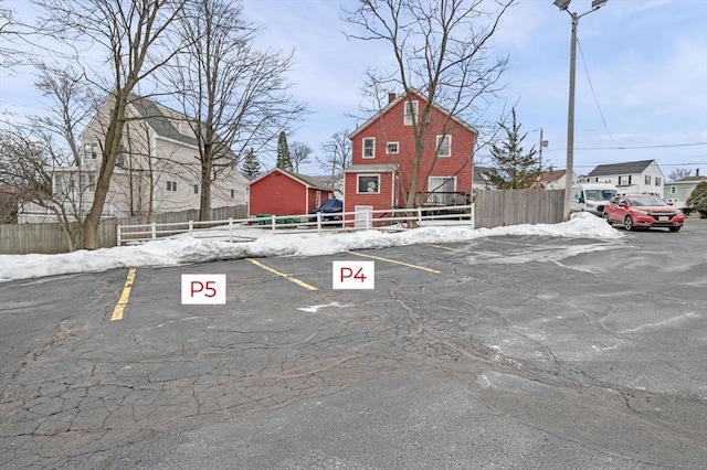 uncovered parking lot featuring fence