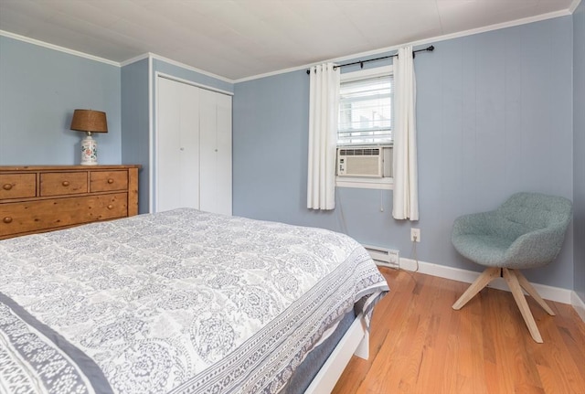 124 Skiff Ave Unit A-11, Tisbury, MA 02568 - bedroom featuring baseboard heating, cooling unit, light wood-type flooring, crown molding, and a closet