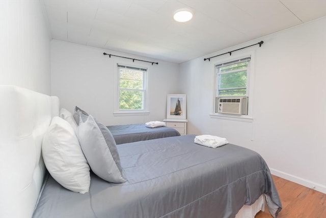 124 Skiff Ave Unit A-11, Tisbury, MA 02568 - bedroom featuring wood finished floors, multiple windows, and cooling unit