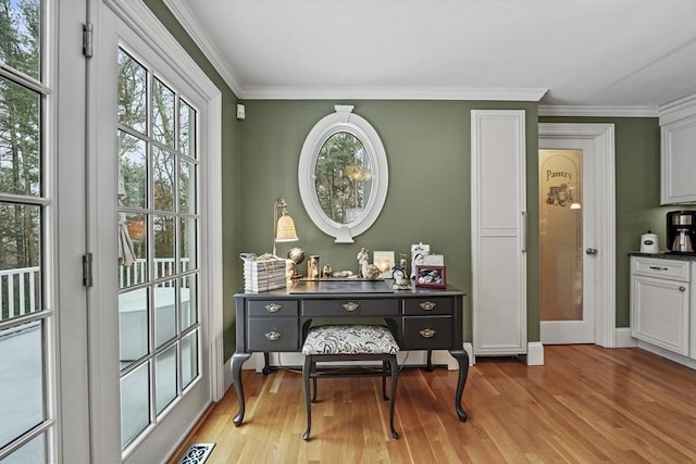 living area featuring ornamental molding, a wealth of natural light, and light wood finished floors