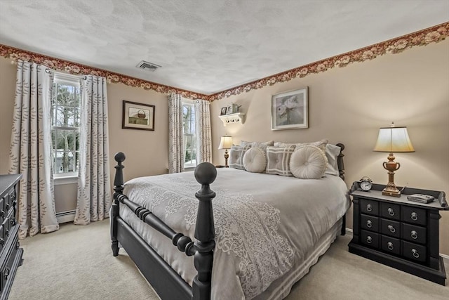 bedroom featuring a baseboard heating unit, light colored carpet, and visible vents