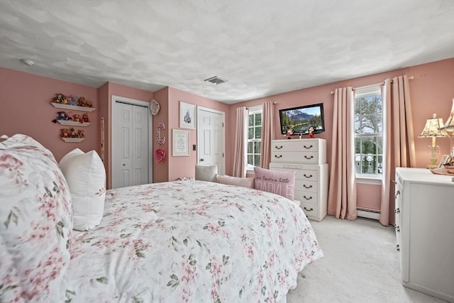 bedroom featuring a baseboard radiator, visible vents, and light colored carpet