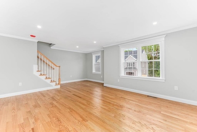 unfurnished living room with ornamental molding and light wood-type flooring