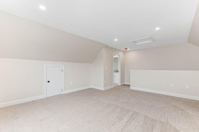 additional living space featuring vaulted ceiling and carpet