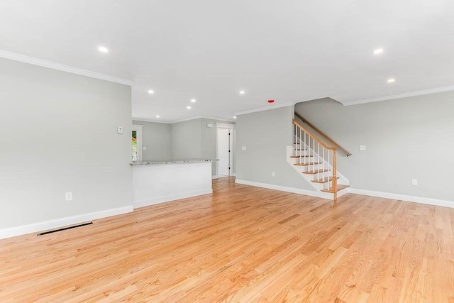 unfurnished living room with crown molding and light hardwood / wood-style flooring