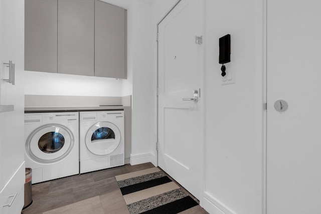 washroom with washing machine and clothes dryer and cabinet space