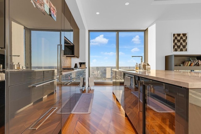 dining area with beverage cooler, floor to ceiling windows, wood finished floors, and recessed lighting