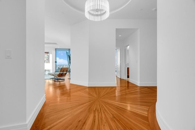 interior space with a chandelier, baseboards, and wood finished floors