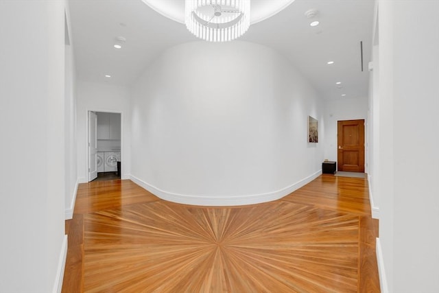 hall featuring baseboards, light wood-style flooring, independent washer and dryer, an inviting chandelier, and recessed lighting