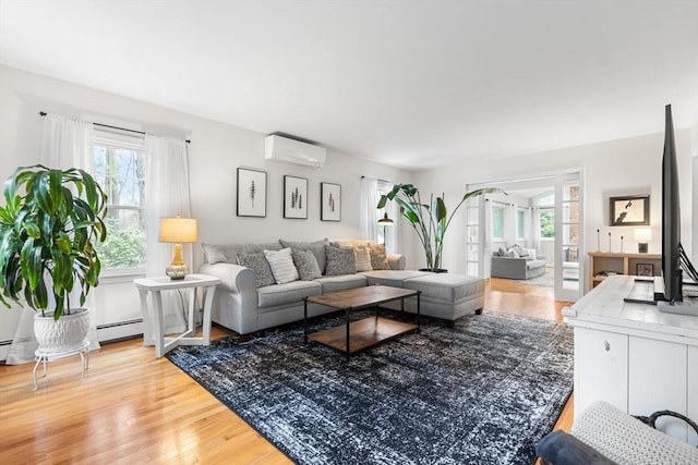 living room featuring a wall mounted air conditioner, a wealth of natural light, and light wood-style floors