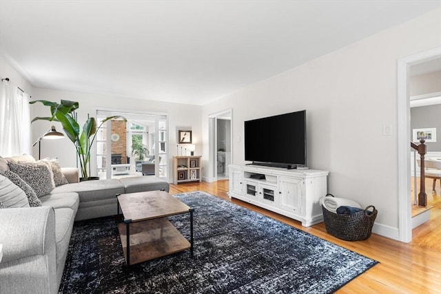 living area with light wood-style flooring and baseboards