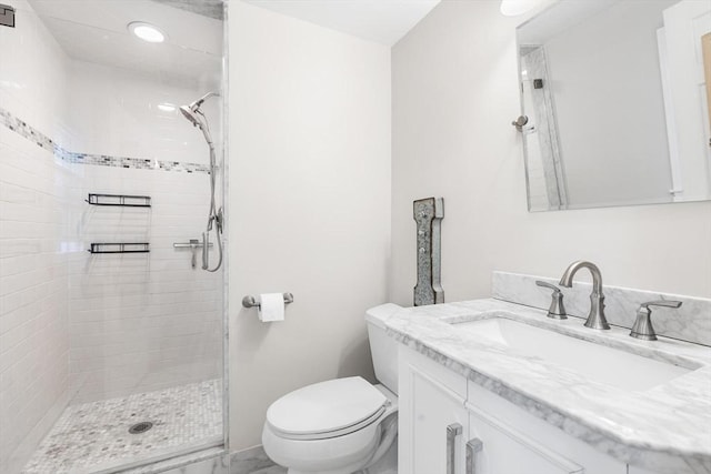 bathroom with toilet, a stall shower, and vanity