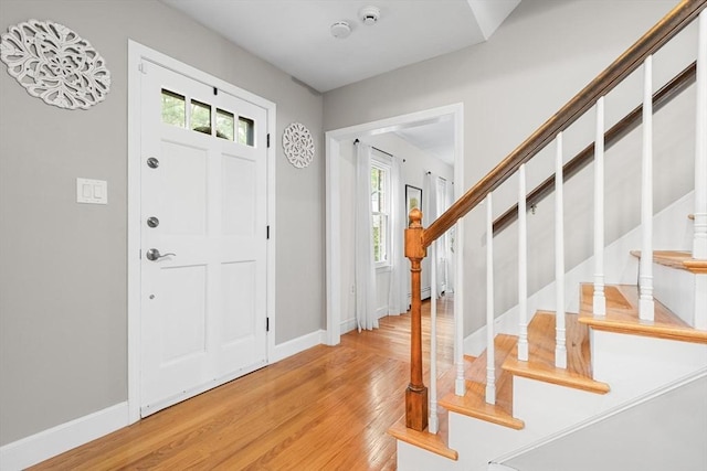 entryway featuring stairs, light wood-style flooring, and baseboards