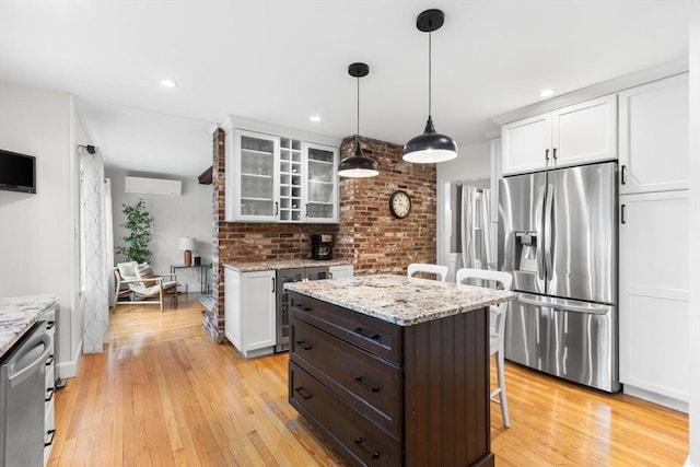 kitchen featuring glass insert cabinets, a breakfast bar, stainless steel appliances, light wood-type flooring, and wine cooler