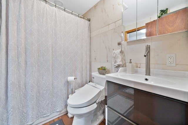 bathroom with curtained shower, tile walls, vanity, and toilet