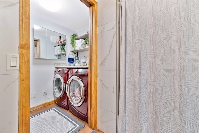 washroom with washer and clothes dryer and hardwood / wood-style floors