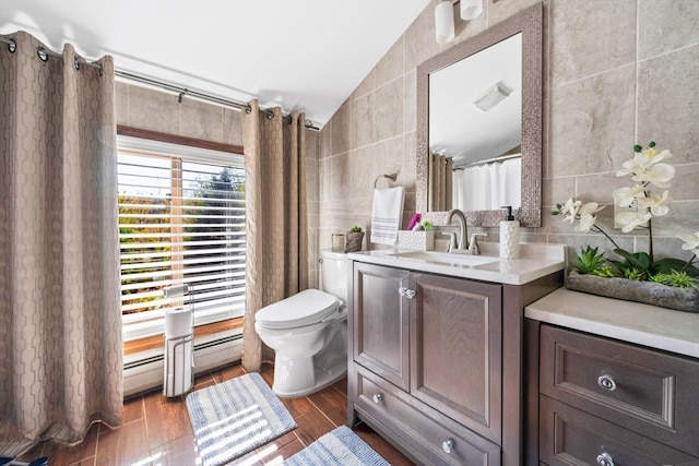 bathroom with vanity, toilet, hardwood / wood-style flooring, tile walls, and vaulted ceiling