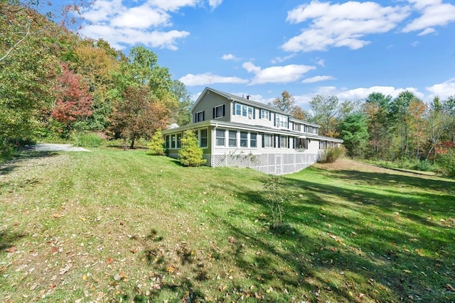 rear view of property featuring a yard and a sunroom